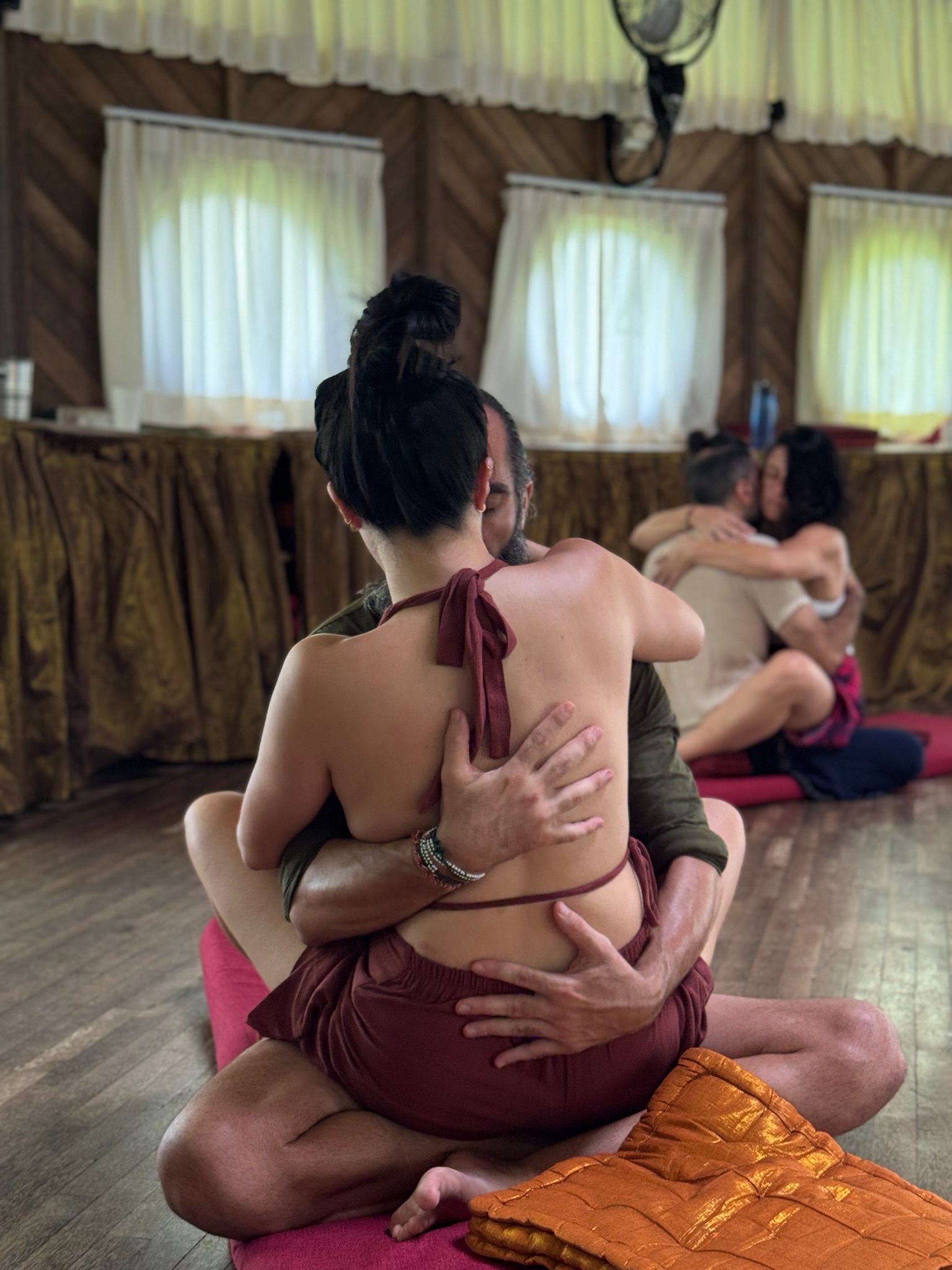 Couples in yab yum position during a retreat session